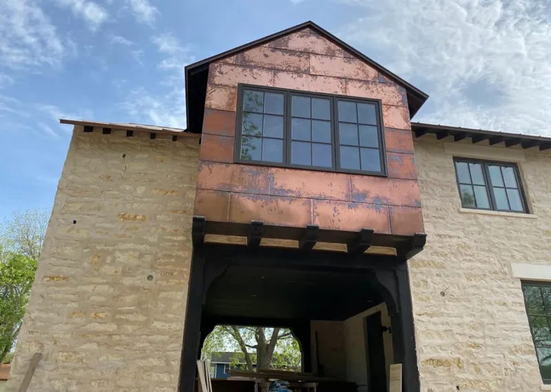 Copper metal panel facade on a stone building for Roof Repair in Orono